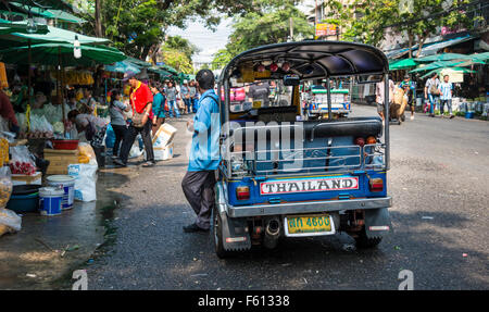 Tuk-tuk chauffeur en attente par sa voiture sur occupation Road, Bangkok, Thaïlande Banque D'Images