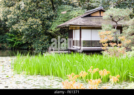 Le Japon, Kyoto, Shosei-en jardin. Avec de l'eau du lac lillies et pavillon en bois, la maison de thé, sochinkyo avec des arbres derrière. Banque D'Images