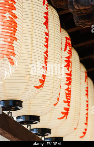 Le Japon, Kyoto, temple Kennin-ji. Ligne d'accrocher des lanternes en papier, blanc, rouge avec Chochin caractères kanji. Close up. Banque D'Images