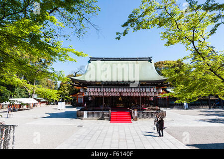 Le Japon, Kyoto, temple shintoïste Yasaka. De lointaines Buden Hall, stade de milieu d'ouvrir place vide, sous ciel bleu. Un soleil brillant. Le printemps. Banque D'Images