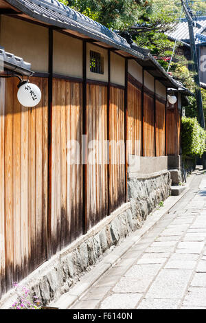 Le Japon, Kyoto, Gion. Mur traditionnel. Base de pierre avec des planches clouées ensemble avec des panneaux de plâtre blanc au-dessus de cela et puis des tuiles du toit. Banque D'Images