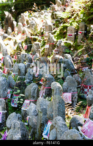 Le Japon, Kyoto, temple Kiyomizu-dera. Sekibutsu-Gun, une banque d'herbe zone couverte dans de nombreux petits Jizo Bosatsu red-bibbed statues en pierre. Le jour, la lumière du soleil. Banque D'Images