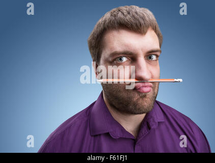 Homme barbu étrange détient avec son nez et crayon lèvres Banque D'Images