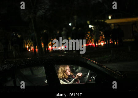 Hambourg, Allemagne. 10 Nov, 2015. Parcs d'une femme son véhicule comme les résidents déposent des fleurs et des bougies à l'extérieur de la maison de l'ancien chancelier allemand Helmut Schmidt, à Hambourg, en Allemagne, le 10 novembre 2015. Helmut Schmidt, qui fut chancelier de l'Allemagne de l'Ouest de 1974 à 1982, est décédé à l'âge de 96 ans à son domicile à Hambourg le mardi après-midi, selon les médias allemands. Credit : Zhang Fan/Xinhua/Alamy Live News Banque D'Images