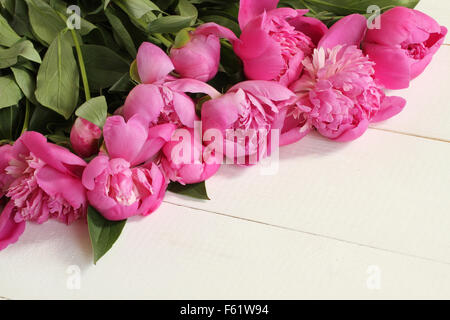 Bouquet de pivoines rose sur fond en bois laqué blanc Banque D'Images