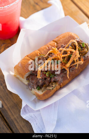 Steak de fromage sandwich sur un papier plat sur une serviette en tissu blanc sur une table en bois avec une pastèque boire dans l'arrière-plan. Banque D'Images