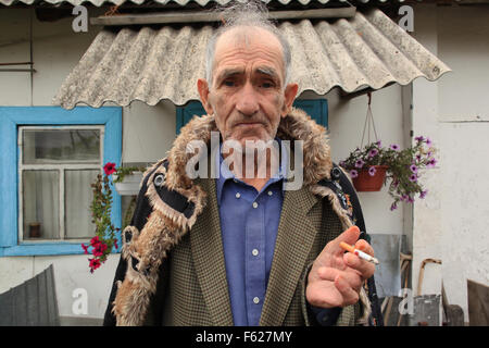 L'Ivan rapatriés Ilchenko (82) en face de sa maison, dans le village, Kupovate situé dans la zone d'exclusion de Tchernobyl. L'Ukraine Banque D'Images