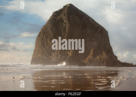 Lumière dramatique et sky at Haystack Rock sur la côte de l'Oregon. Haystack Rock est un 235 pieds pile dans la mer, Cannon Beach Oregon Banque D'Images