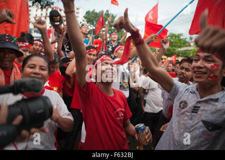 Les partisans de l'opposition au Myanmar, Aung San Suu Kyi célébrer comme ils regardent les résultats officiels des élections à l'extérieur de la Ligue nationale de la démocratie (LND) siège à Yangon . Les partisans d'Aung San Suu Kyi, pro-démocratie et acclamés à excitation croissante que les premiers résultats de l'élection historique du Myanmar ont stimulé l'espoir de gains de balayage pour le porter au pouvoir après des décennies de domination militaire. Banque D'Images