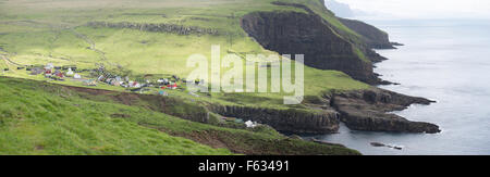 Panorama du village mykines sur les îles Féroé avec des falaises et l'océan bleu vert herbe Banque D'Images