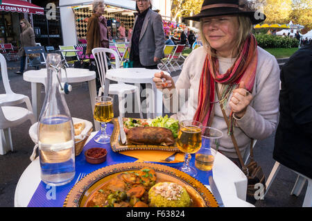 Une femme souriante mangeant un pot-de-vin marocain (poulet) Restaurant coeur d'Amande, St Aubin, Toulouse, France plat extérieur Banque D'Images