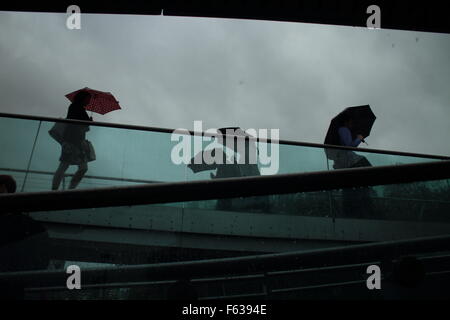 Les gens qui marchent sur le pont du Millenium à Londres un jour de pluie Banque D'Images