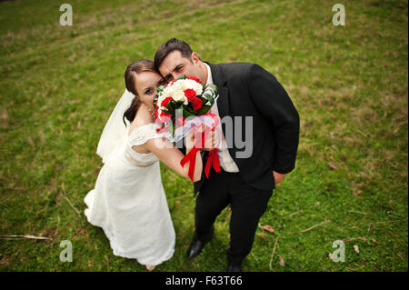 Wedding couple caché ils visage derrière un bouquet Banque D'Images