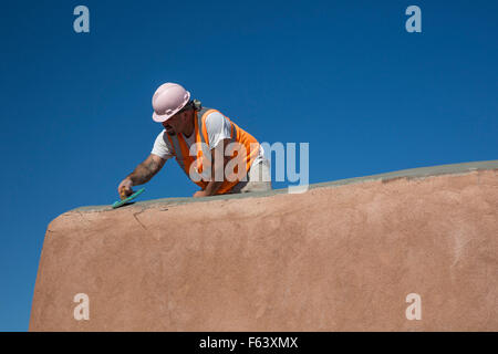 Alamogordo, Nouveau Mexique - réparations d'un travailleur d'une construction d'adobe au centre des visiteurs de White Sands National Monument. Banque D'Images