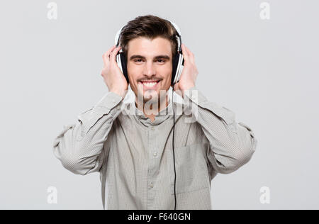 Happy handsome young man in earphones écouter de la musique Banque D'Images