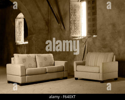 Éléments ménage canapé et fauteuil dans un grand vide intérieur avec des fenêtres ouvertes Banque D'Images