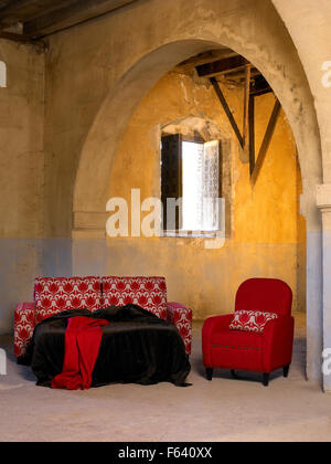 Éléments ménage canapé, lit et fauteuil dans un grand vide intérieur avec fenêtre ouverte à la verticale Banque D'Images