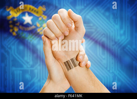 Numéro ID code barre tatoo sur poignet et USA statesl drapeau sur arrière-plan - Nevada Banque D'Images