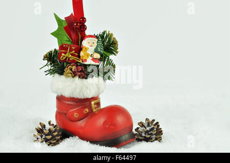 Père Noël avec branches de sapin à l'intérieur d'un soufflet rouge avec de la fourrure blanche découpage sur blanc, snowy background, Close up, horizontal Banque D'Images