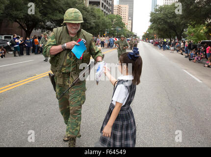 L'intention des enfants du primaire donner des cartes faites à la main pour les anciens combattants militaires pendant la Veteran's Day Parade Banque D'Images
