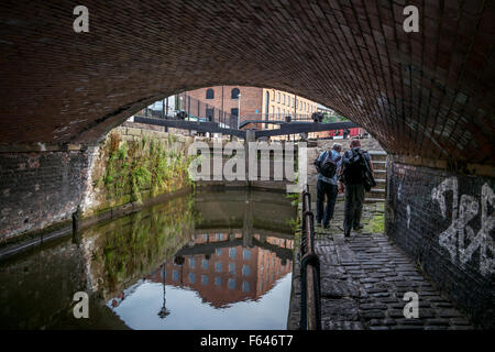 Deux hommes à marcher le long du chemin de halage de l'appareil photo le long de la p16 dans le centre-ville de Manchester Banque D'Images