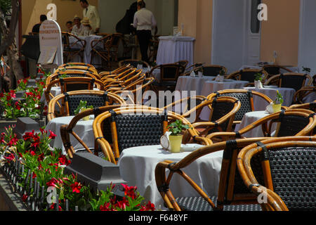 Restauration à l'extérieur au soleil en vacances de belles tables et chaises fleurs bel emplacement long déjeuner service à table menu du haut. Banque D'Images