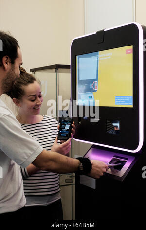 Jeune couple à l'aide d'une monnaie numérique atm bitcoin england uk Banque D'Images