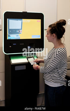 Jeune femme à l'aide d'une monnaie numérique atm bitcoin england uk Banque D'Images