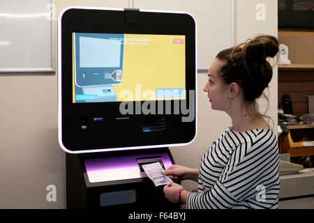 Jeune femme à l'aide d'une monnaie numérique atm bitcoin england uk Banque D'Images