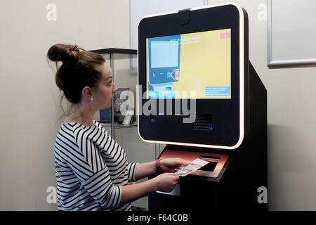 Jeune femme à l'aide d'une monnaie numérique atm bitcoin england uk Banque D'Images