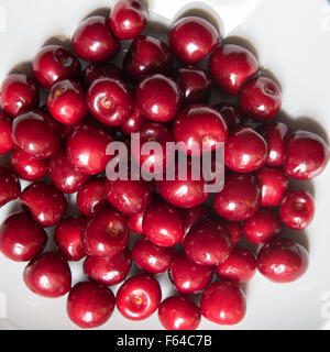 Bol d cerries frais rouge sur fond blanc Banque D'Images