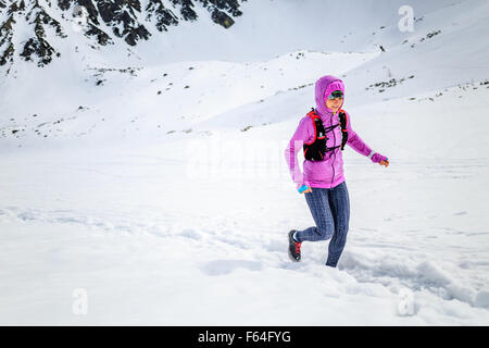 Le trail running woman runner dans les montagnes d'hiver sur la neige. La motivation et l'inspiration concept de remise en forme avec de belles vues Banque D'Images