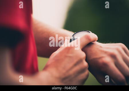 L'utilisation de canaux chauds formation moniteur de fréquence cardiaque en cours d'exécution, les performances du contrôle smartwatch ou GPS. L'homme à l'athlète au chronomètre. Banque D'Images