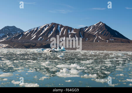 La Norvège, mer de Barents, Svalbard, Spitzberg. La baie calme et paysage de montagne en face du 14 juillet Glacier. Banque D'Images