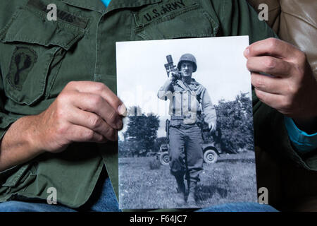 Powder Springs, GA, USA. 11Th Nov, 2015. DAVID THOMAS, un ancien combattant de l'Armée de la guerre du Vietnam, pose pour un portrait tout en tenant une photo de son père qui était un photographe de combat durant la Seconde Guerre mondiale. Thomas déployés au Vietnam à partir de 1970-1971. © Branden Camp/ZUMA/Alamy Fil Live News Banque D'Images