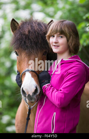 Cheval islandais. Girl standing next to bay adulte. L'Autriche Banque D'Images