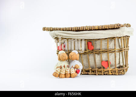 Deux moutons figurines en face d'un panier en rotin vintage, sur un fond blanc Banque D'Images