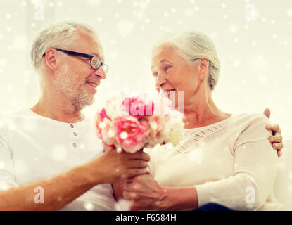 Happy senior couple avec bouquet de fleurs à la maison Banque D'Images