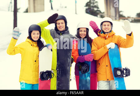 Happy friends dans casques avec snowboards Banque D'Images