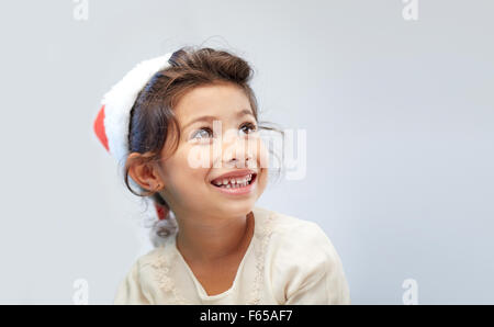 Happy little girl in santa hat plus de Gray Banque D'Images