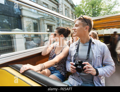 Smiling couple avec caméra voyageant par autobus de tournée Banque D'Images