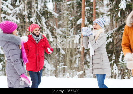 Heureux amis jouant dans la forêt hiver neige Banque D'Images