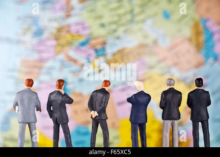 D'affaires comme des figurines en face d'un globe. Banque D'Images