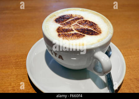 Pochoir chocolat grains de café sur le dessus du verre cappuccino Banque D'Images