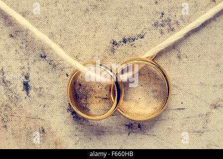 Les anneaux de mariage pendaison sur corde. Image vintage. Banque D'Images