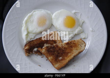 Deux œufs plus facile de faire un smiley avec toast sur une assiette blanche Banque D'Images