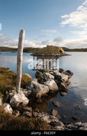 Chaussée de pierre menant à l'âge de fer galerie Baravat Dun dun ou des brochures sur une petite île dans le Loch Barabhat, Great Bernera, à l'île de Lewis. Banque D'Images