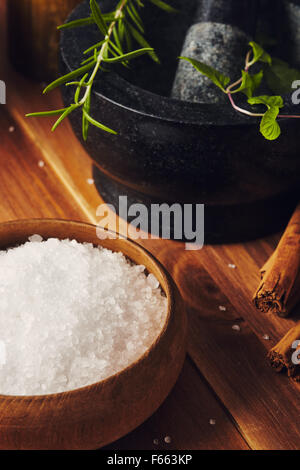 Outils Spa, bath salt, mortier avec des herbes, un bol avec des pierres chaudes et des bougies, quelques bâtons de cannelle sur la table Banque D'Images