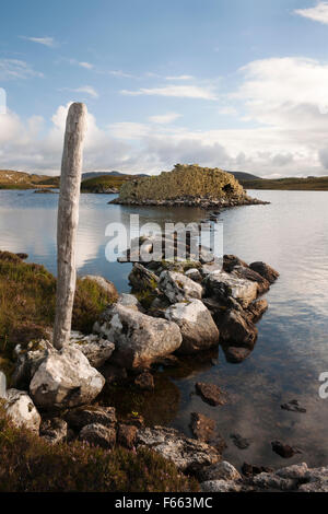 Chaussée de pierre menant à l'âge de fer galerie Baravat Dun dun ou des brochures sur une petite île dans le Loch Barabhat, Great Bernera, à l'île de Lewis. Banque D'Images