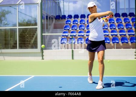 Belle tennis player en action, frapper un coup droit Banque D'Images